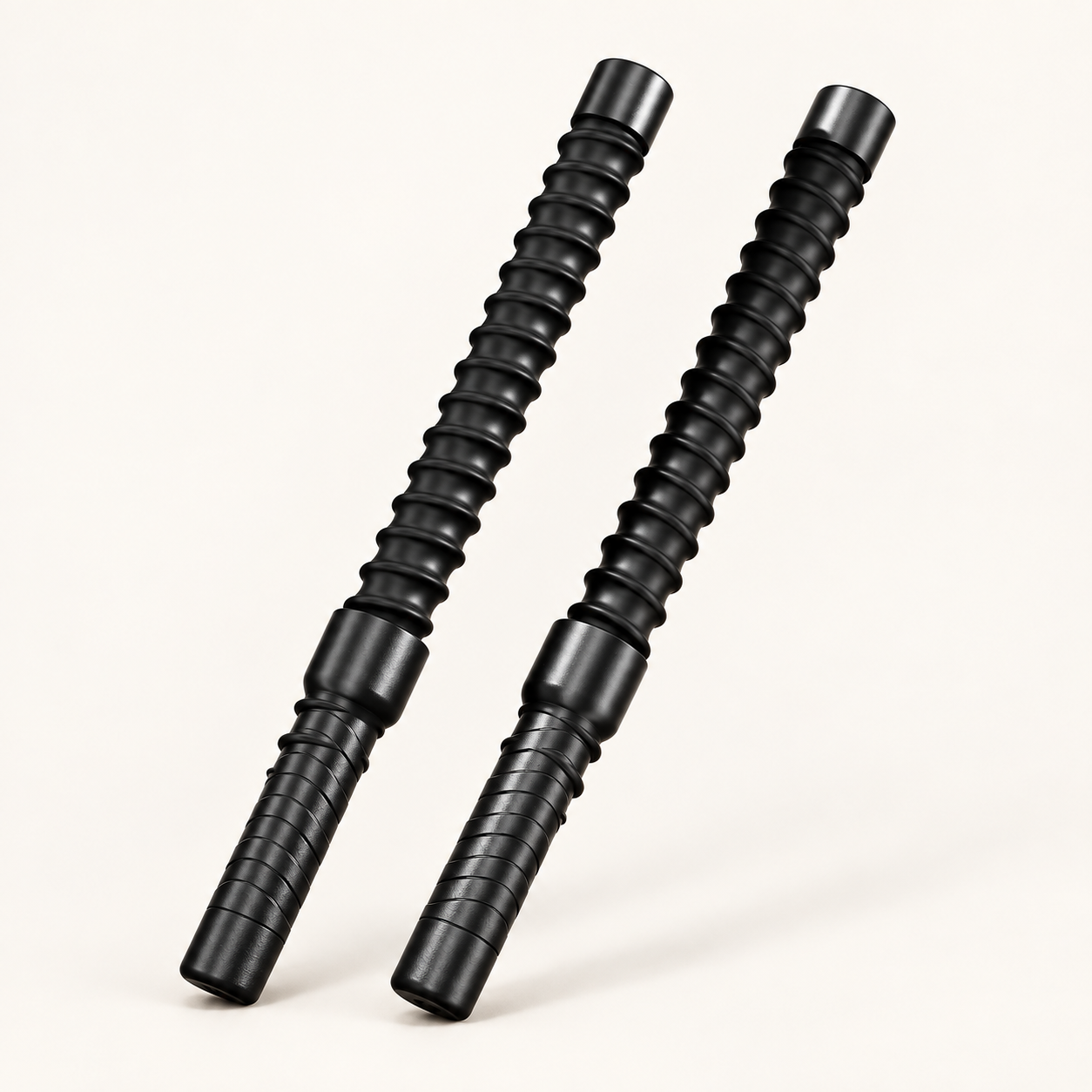 Two black Enduro cordless battle ropes on a warm ivory background